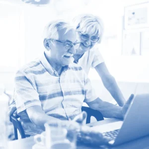 Elderly couple looking over a computer.