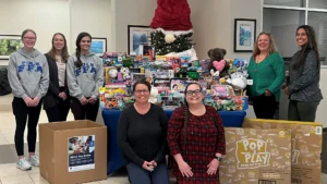 Group gathers near holiday Toy Drive collection table at SECU branch 