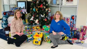 Branch employees gathered near Toy Drive donations at SECU branch 